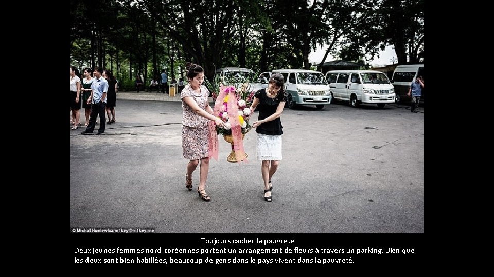 Toujours cacher la pauvreté Deux jeunes femmes nord-coréennes portent un arrangement de fleurs Toujours cacher la pauvreté Deux jeunes femmes nord-coréennes portent un arrangement de fleurs