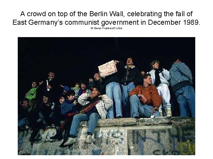 A crowd on top of the Berlin Wall, celebrating the fall of East Germany’s