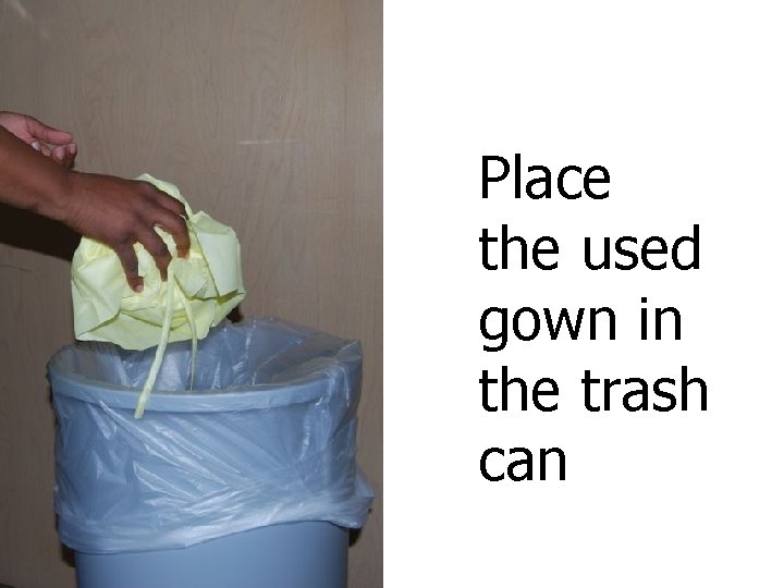 Place the used gown in the trash can 