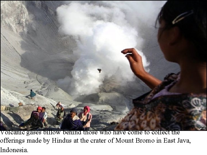 Volcanic gases billow behind those who have come to collect the offerings made by Volcanic gases billow behind those who have come to collect the offerings made by