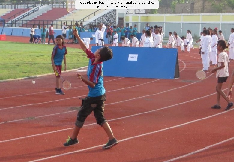 Kids playing badminton, with karate and athletics groups in the background 