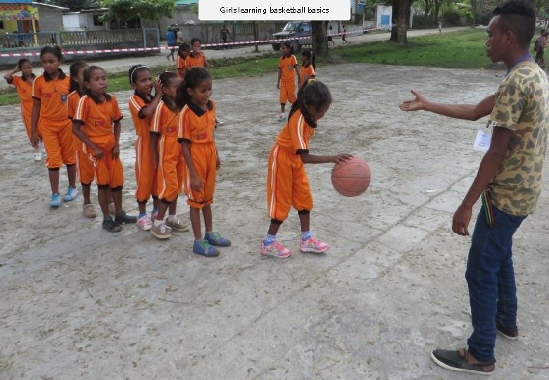 Girls learning basketball basics 