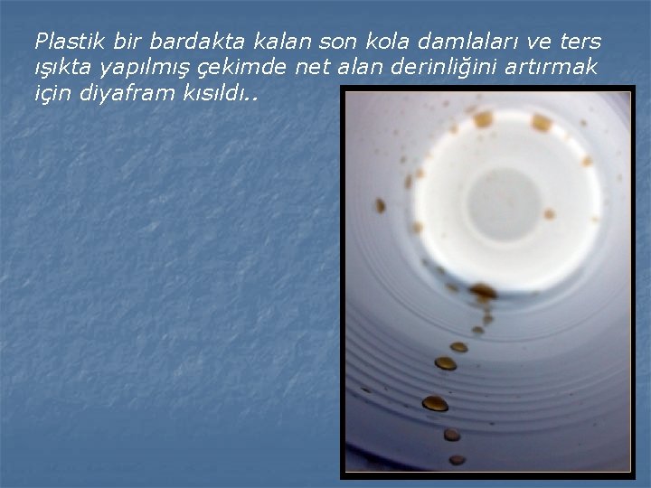 Plastik bir bardakta kalan son kola damlaları ve ters ışıkta yapılmış çekimde net alan