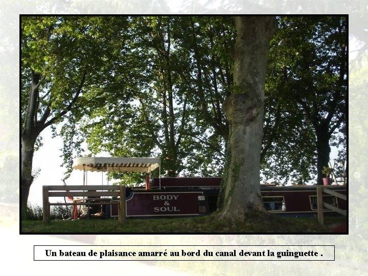 Un bateau de plaisance amarré au bord du canal devant la guinguette. 