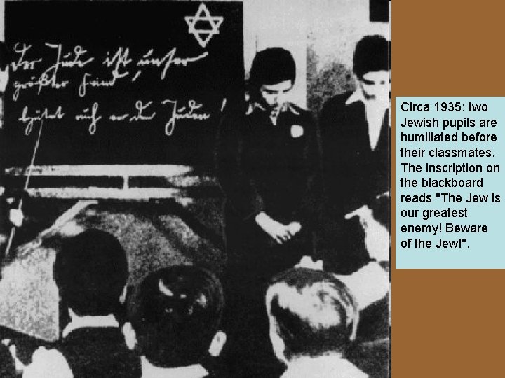 Circa 1935: two Jewish pupils are humiliated before their classmates. The inscription on the