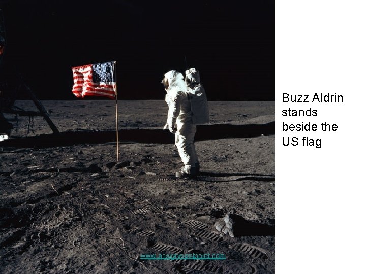 Buzz Aldrin stands beside the US flag www. assignmentpoint. com 