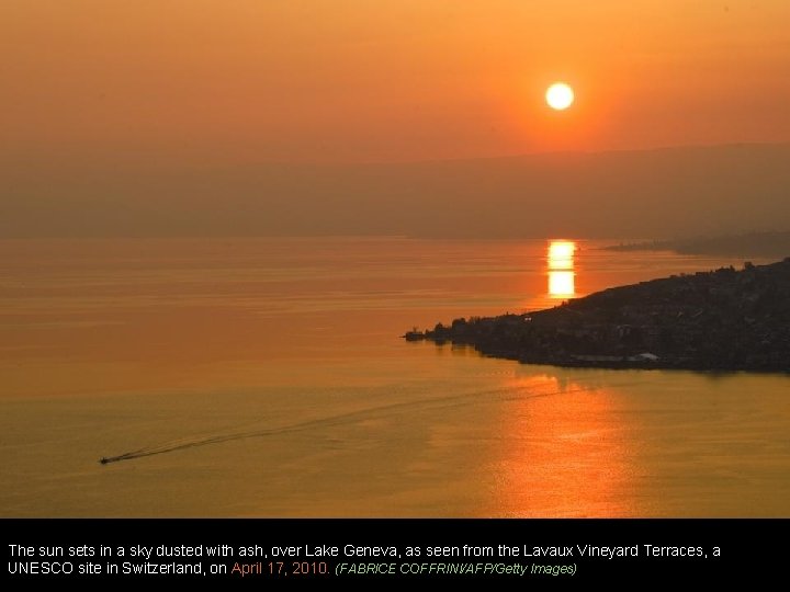 The sun sets in a sky dusted with ash, over Lake Geneva, as seen