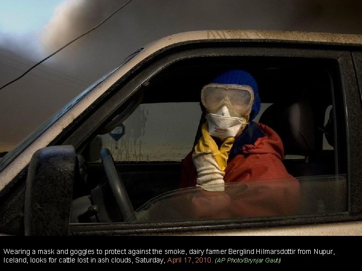 Wearing a mask and goggles to protect against the smoke, dairy farmer Berglind Hilmarsdottir