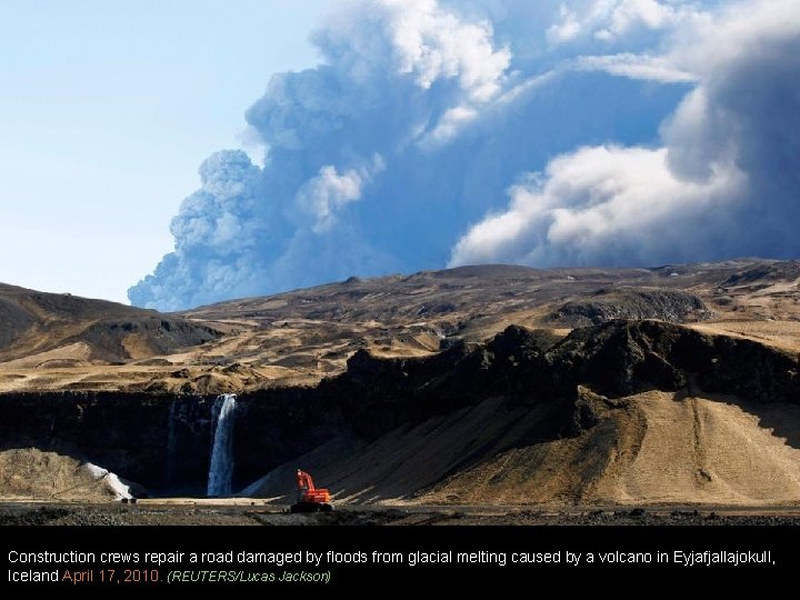 Construction crews repair a road damaged by floods from glacial melting caused by a