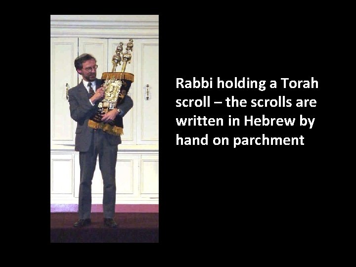 Rabbi holding a Torah scroll – the scrolls are written in Hebrew by hand