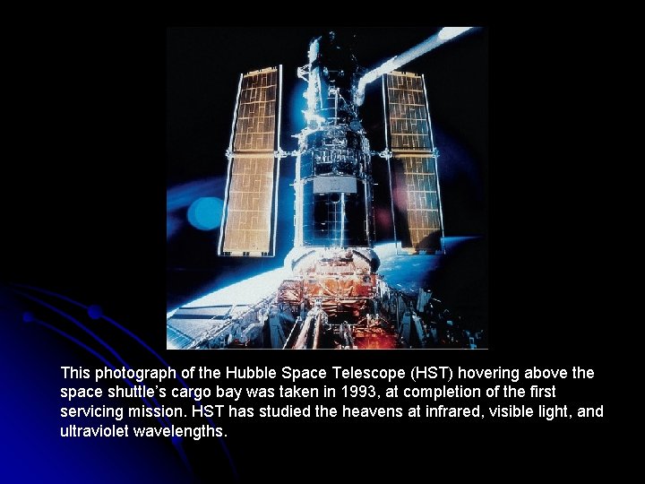 This photograph of the Hubble Space Telescope (HST) hovering above the space shuttle’s cargo