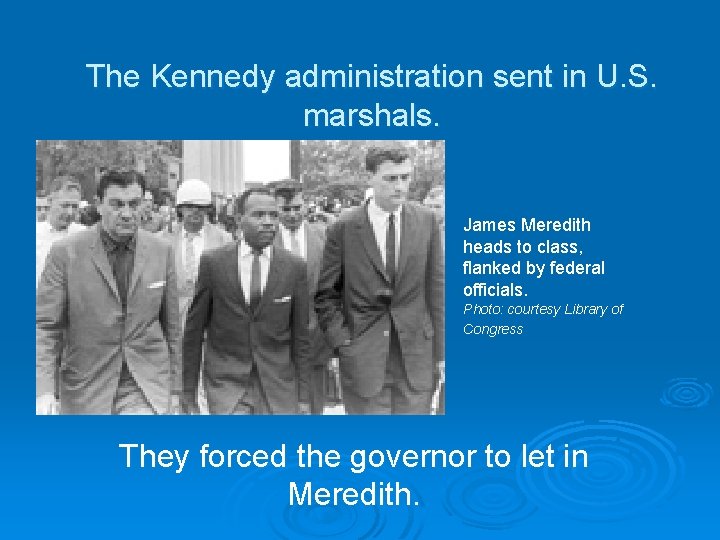 The Kennedy administration sent in U. S. marshals. James Meredith heads to class, flanked