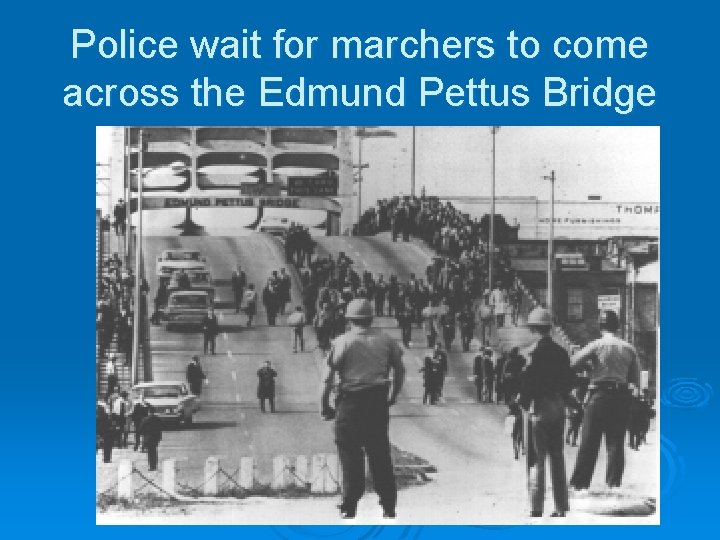 Police wait for marchers to come across the Edmund Pettus Bridge 
