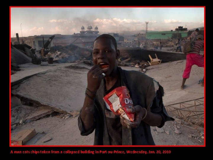 A man eats chips taken from a collapsed building in Port-au-Prince, Wednesday, Jan. 20,