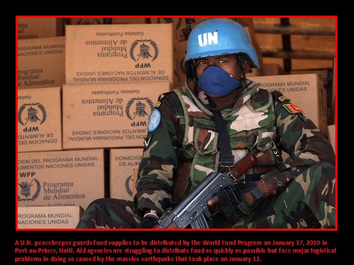A U. N. peacekeeper guards food supplies to be distributed by the World Food