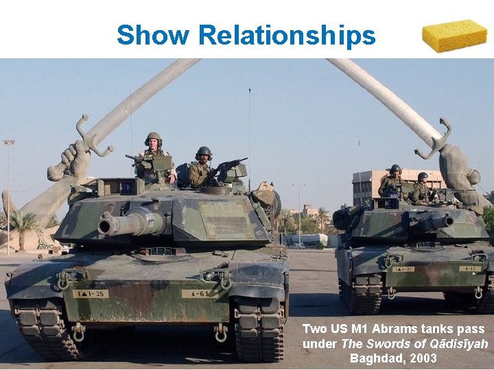 Show Relationships Two US M 1 Abrams tanks pass under The Swords of Qādisīyah