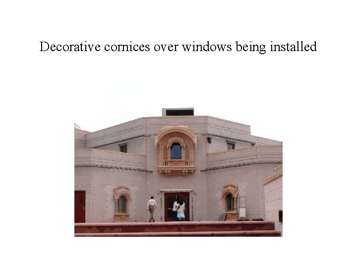 Decorative cornices over windows being installed 