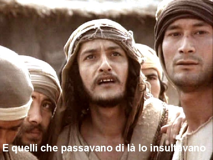 E quelli che passavano di là lo insultavano 