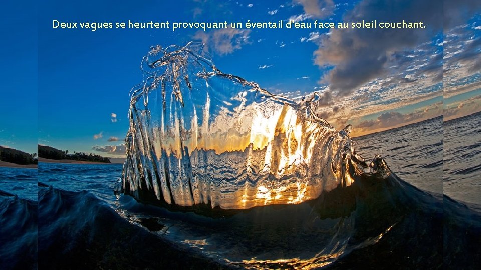 Deux vagues se heurtent provoquant un éventail d'eau face au soleil couchant. 