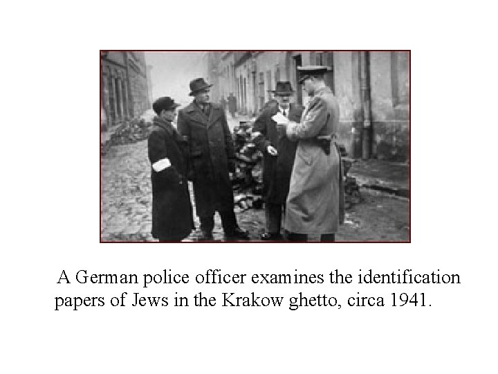 A German police officer examines the identification papers of Jews in the Krakow ghetto,