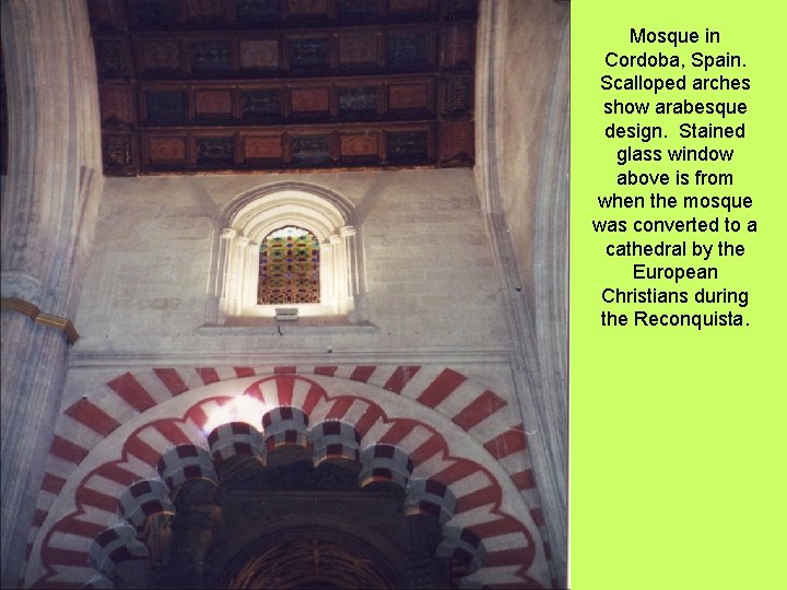 Mosque in Cordoba, Spain. Scalloped arches show arabesque design. Stained glass window above is