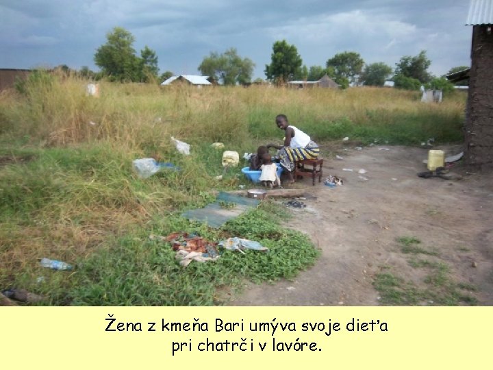 Žena z kmeňa Bari umýva svoje dieťa pri chatrči v lavóre. 