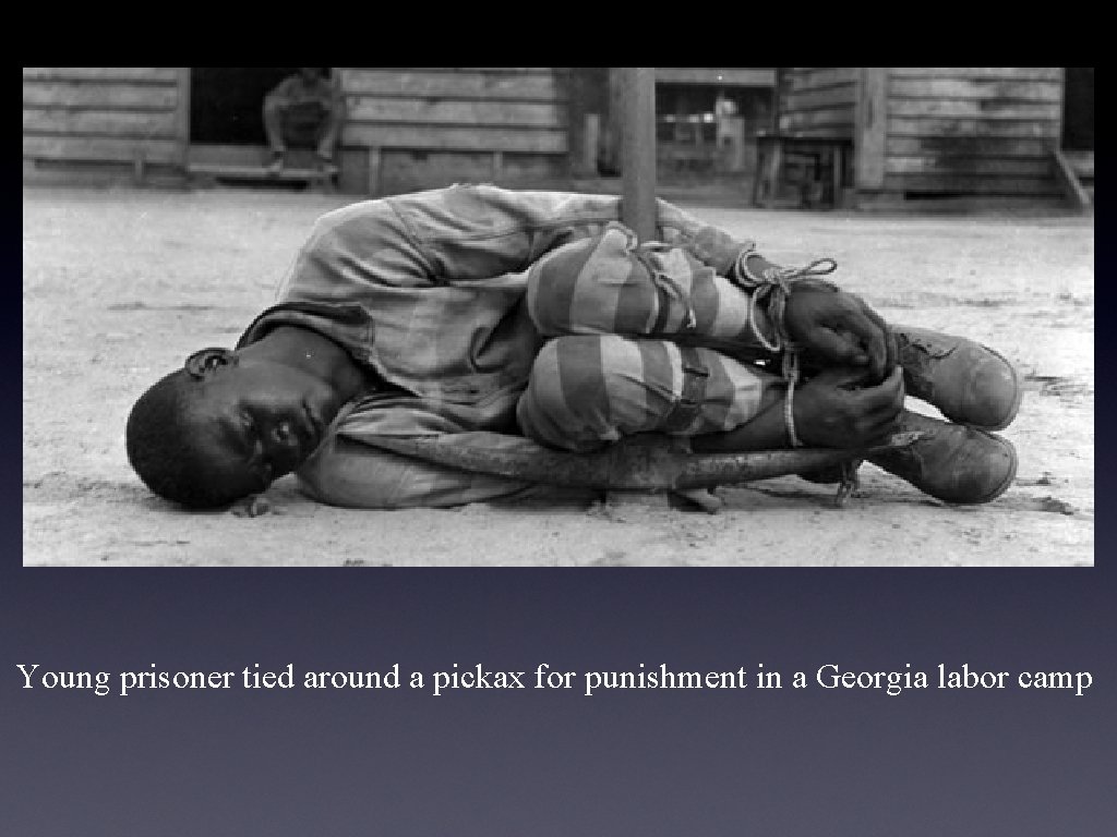 Young prisoner tied around a pickax for punishment in a Georgia labor camp 