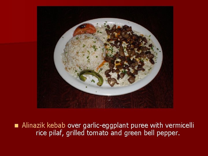 n Alinazik kebab over garlic-eggplant puree with vermicelli rice pilaf, grilled tomato and green