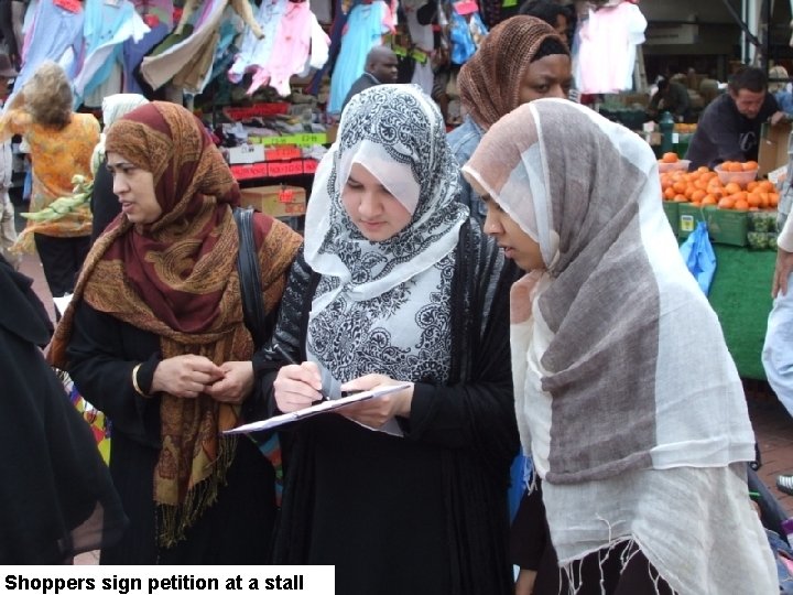 Shoppers sign petition at a stall 