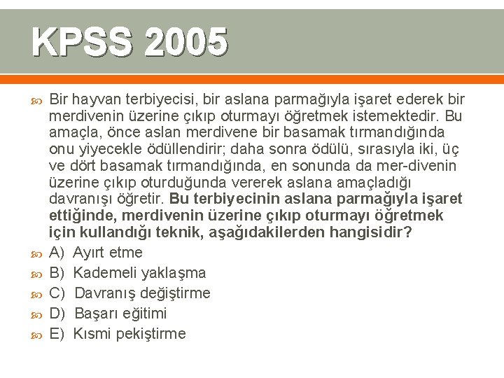 KPSS 2005 Bir hayvan terbiyecisi, bir aslana parmağıyla işaret ederek bir merdivenin üzerine çıkıp