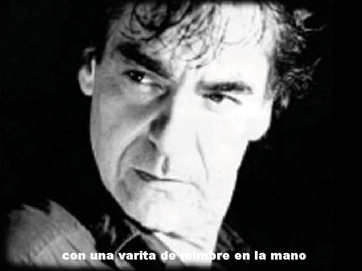 con una varita de mimbre en la mano 