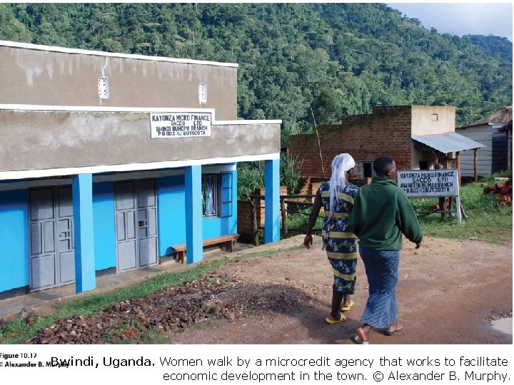 Bwindi, Uganda. Women walk by a microcredit agency that works to facilitate economic development