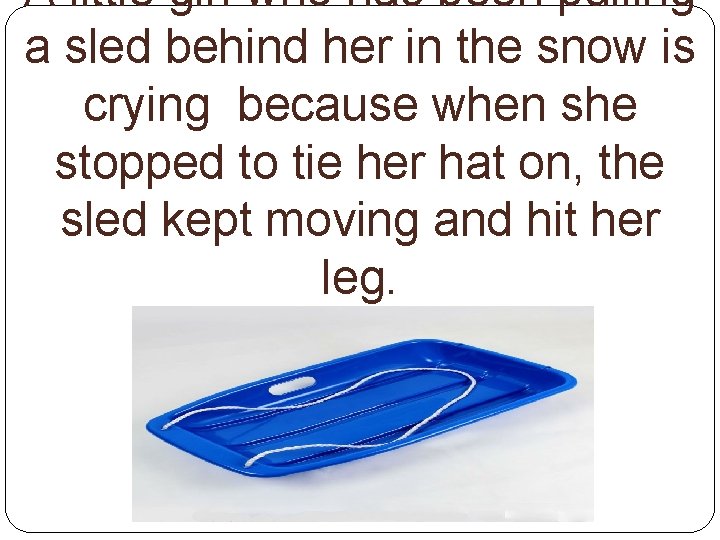 A little girl who has been pulling a sled behind her in the snow
