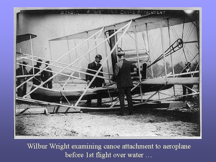 Wilbur Wright examining canoe attachment to aeroplane before 1 st flight over water …