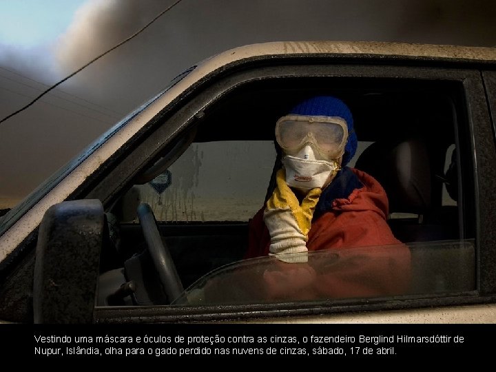 Vestindo uma máscara e óculos de proteção contra as cinzas, o fazendeiro Berglind Hilmarsdóttir