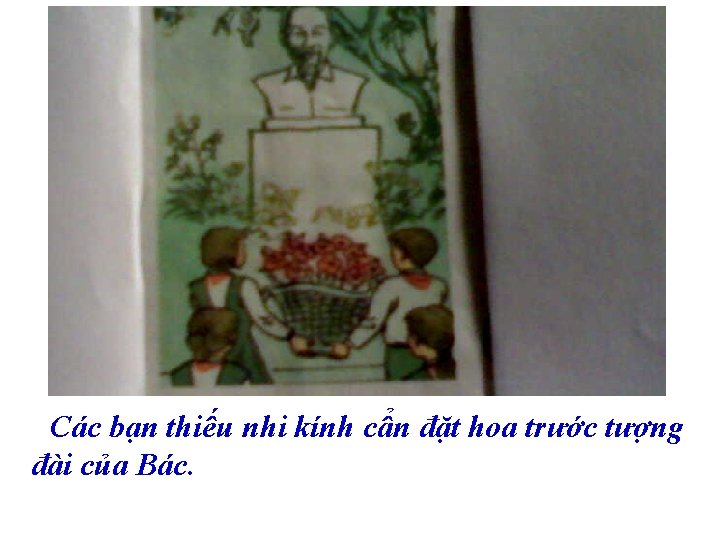 Các bạn thiếu nhi kính cẩn đặt hoa trước tượng đài của Bác. 