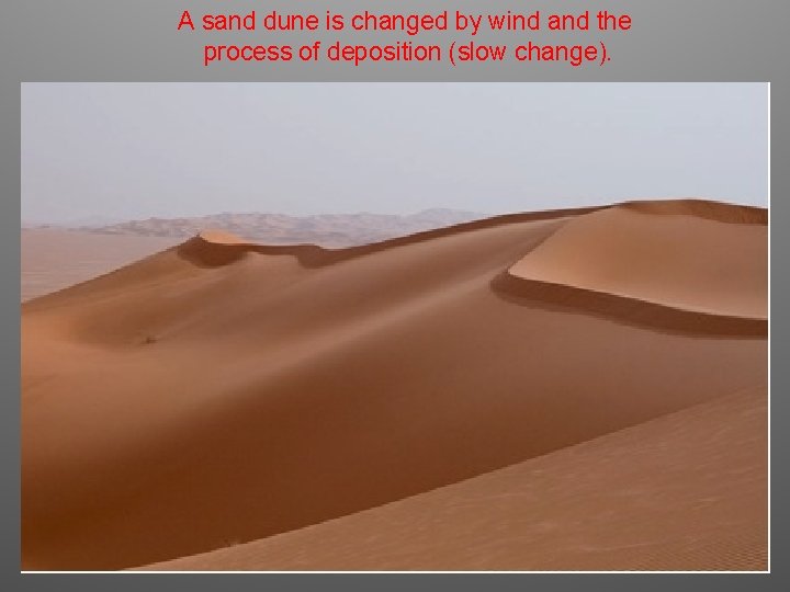 A sand dune is changed by wind and the process of deposition (slow change).
