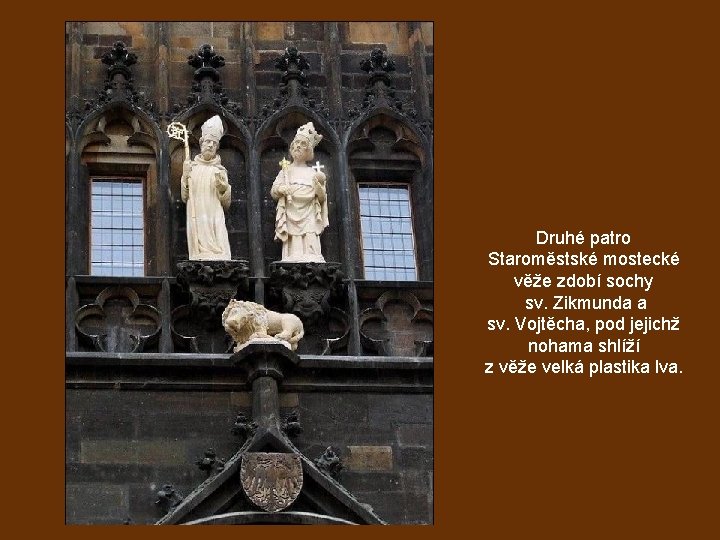 Druhé patro Staroměstské mostecké věže zdobí sochy sv. Zikmunda a sv. Vojtěcha, pod jejichž