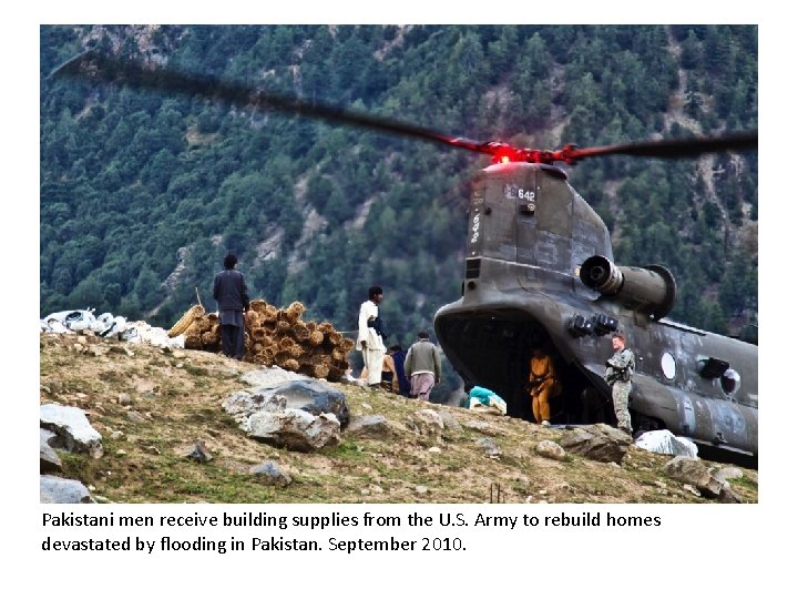 Pakistani men receive building supplies from the U. S. Army to rebuild homes devastated