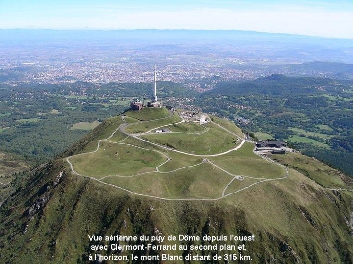 Vue aérienne du puy de Dôme depuis l'ouest avec Clermont-Ferrand au second plan et,