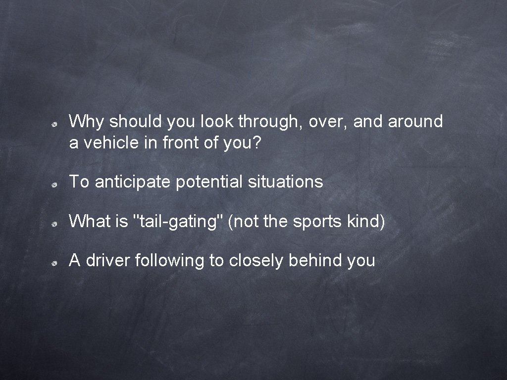 Why should you look through, over, and around a vehicle in front of you?