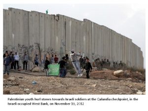 Palestinian youth hurl stones towards Israeli soldiers at